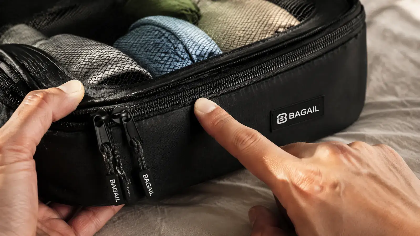 Close-up of a BAGAIL compression cube zipper track showing wear patterns after extended use, held in a person's hand