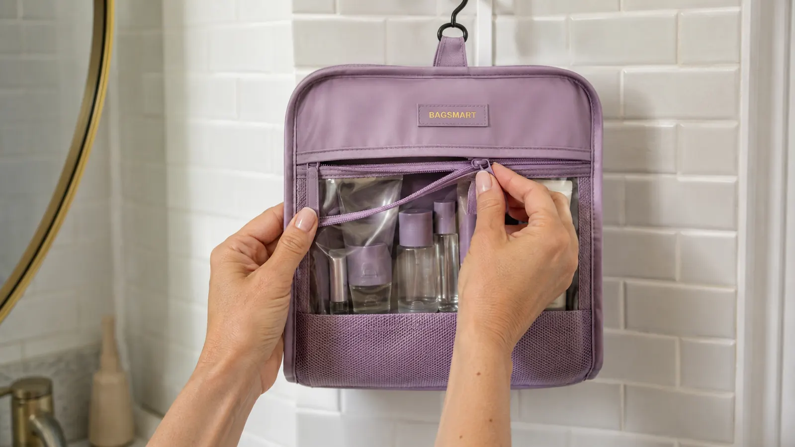 Hands unzipping the clear TSA-approved cosmetic window of the BAGSMART toiletry bag to show travel-size bottles inside