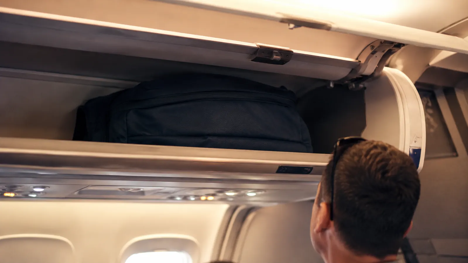 Anti-theft backpack in the overhead bin of an airplane with the security zipper facing inward toward the seat