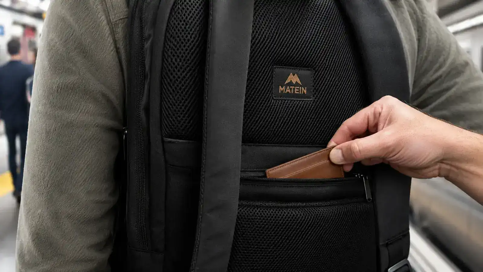 Close-up of hidden anti-theft zipper on the back panel of the MATEIN backpack pressed against a traveler's back